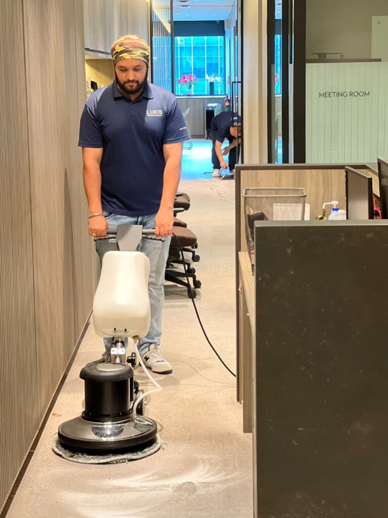 Lukis cleaner shampooing an office corridor carpet with a rotary machine