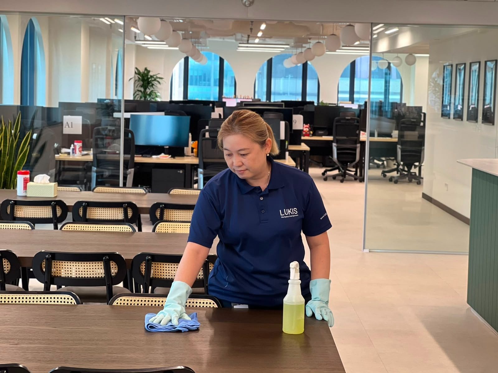 Lukis office cleaner wiping down a pantry table in a Singapore office